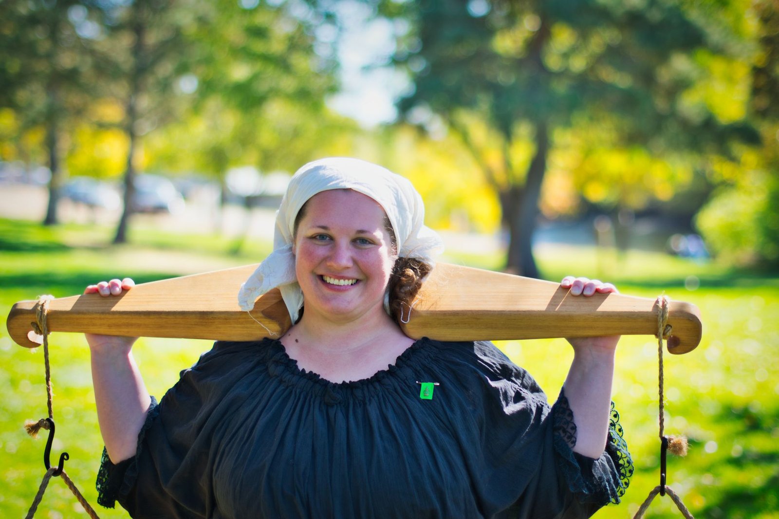 smiling woman carrying wooden yoke